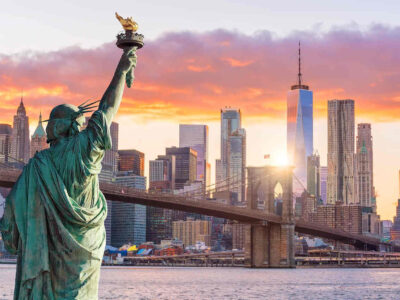 Statue Liberty and New York city skyline at sunset